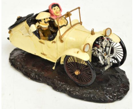 R WEBB; a model of a three wheeled Morgan with moustachioed gent and buxom woman seated, signed to the base, length 32cm.