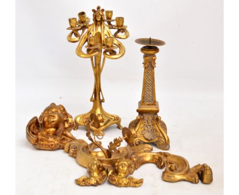 After ERTE; a modern gilt painted Art Nouveau style candelabrum, a pricket candlestick, three cherub's heads, and a wall scon