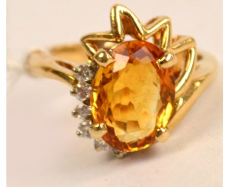 A contemporary 14ct yellow gold ring set with oval cut citrine beside six diamonds, ring size L.