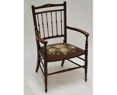 An Edwardian mahogany and inlaid elbow chair with padded seat and ring turned front legs.