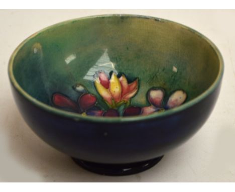 A small modern Moorcroft footed circular bowl, the interior decorated with "Spring Flowers" pattern on blue/turquoise ground,