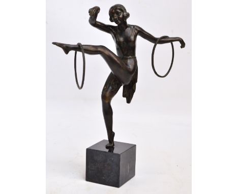 An Art Deco style spelter figure of a gymnast dancing with hoops balancing on one leg, raised on polished marble cubic, indis