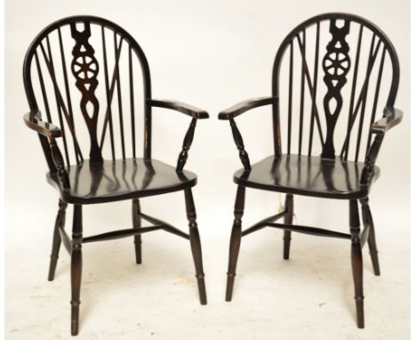 A pair of wheel back elbow chairs with ring turned front legs.