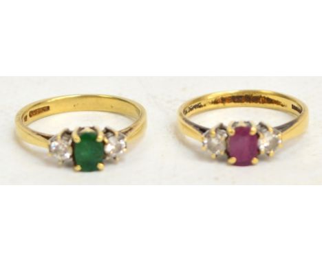 An 18ct yellow gold dress ring, the emerald coloured stone flanked with two diamonds and an identical example with ruby colou