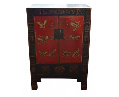 A small Oriental cabinet with gilt decoration on a black lacquer ground, the pair of hinged doors enclosing a shelf, the door