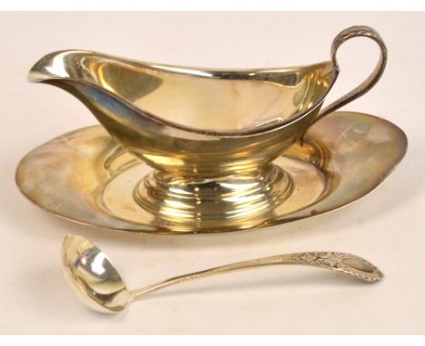 A 20th century American sterling silver sauce boat of plain form, raised on oval spreading base attached to a saucer, length 