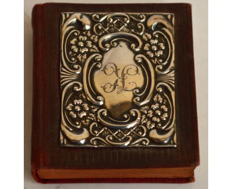 An Edward VII hallmarked silver covered miniature book "Initiation of Christ", engraved with K within a scroll and floral emb