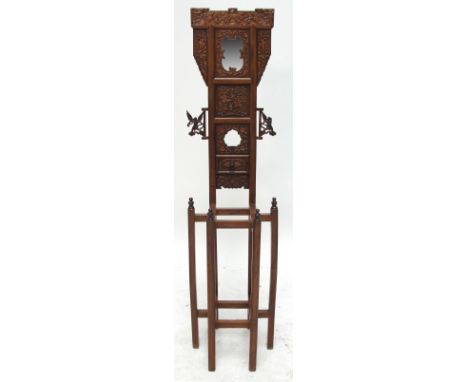 A decorative 20th century Korean carved wash stand with central mirror flanked by and above carved panels decorated with figu