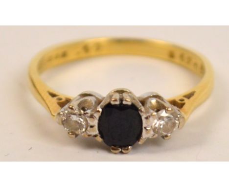 An 18ct yellow gold three stone ring with sapphire flanked by two diamonds in claw setting, size K/L, Birmingham 1988, approx