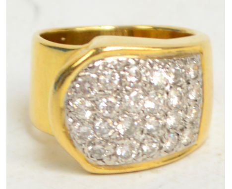 A modern pave set diamond ring with twenty-three small diamonds in a white metal shaped setting, set on to a broad yellow met