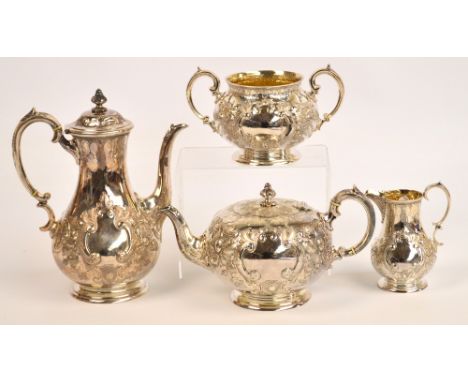 A Victorian hallmarked silver four piece tea service of rounded form with ornate flower and scrolling foliate decoration with
