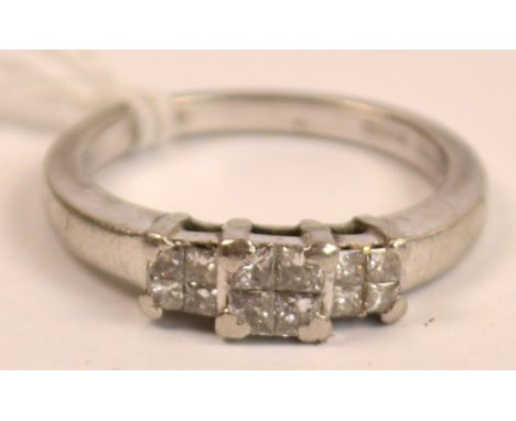 A platinum diamond set ring with three panels each set with four small diamonds, rings size O.