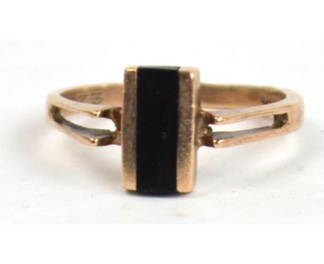 A 9ct yellow gold dress ring with single horizontal black enamel band on pierced shoulders, size M/L (small chip to enamel).