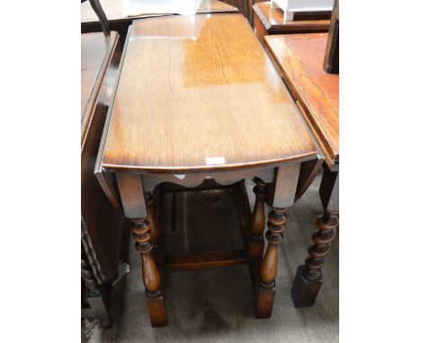 A reproduction oak gateleg dropleaf table raised on ring turned baluster and block supports.