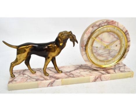 An Art Deco style French marble and onyx mantel clock with circular dial set with Arabic numerals, mountain beside a dog with
