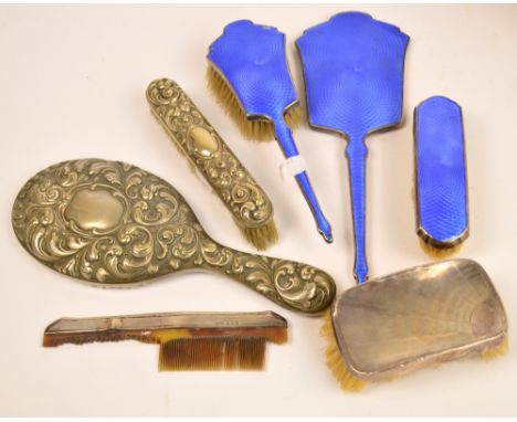 A matched George V hallmarked silver and blue guilloche enamel decorated four piece dressing table set comprising hand mirror