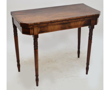 A Georgian mahogany foldover tea table with canted corners, raised on ring turned supports to peg feet, width 91cm.