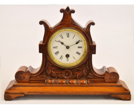 A c.1900 walnut framed mantel clock with circular white enamel dial set with Roman numerals, and a stepped rectangular plinth