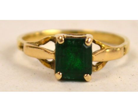 A square cut emerald ring set on a yellow gold band (mark obscured) with pierced shoulders, size I. CONDITION REPORT: There i