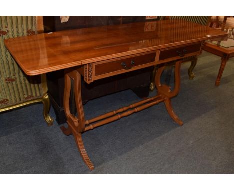 A reproduction yew wood sofa table, with lyre form supports, joined by twin stretchers, 77cm by 151cm by 51cm 