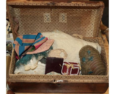 19th century hinged leather mounted dolls trunk with papered lining, enclosing a 19th century blue silk dolls two piece outfi