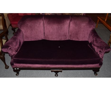 A 1920s sofa upholstered in purple velvet, with mahogany frame