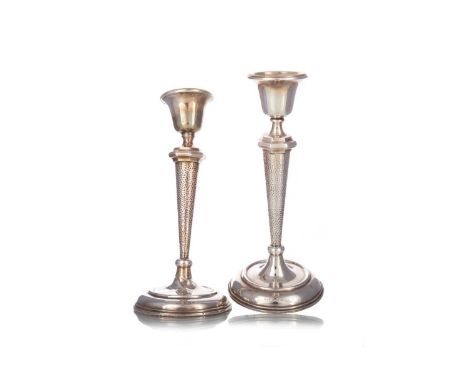 PAIR OF GEORGE V SILVER CANDLESTICKS, MAKER H.W. LTD., BIRMINGHAM 1911 with urn shaped nozzles over hammered tapered columns,