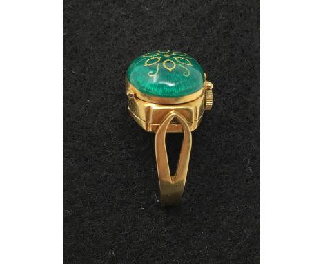 An 18ct gold ring set with a hinged enamel lid enclosing a watch, No. 1401, size M.
