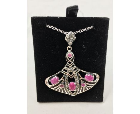An Art Nouveau style sliver, marcasite and ruby pendant necklace.