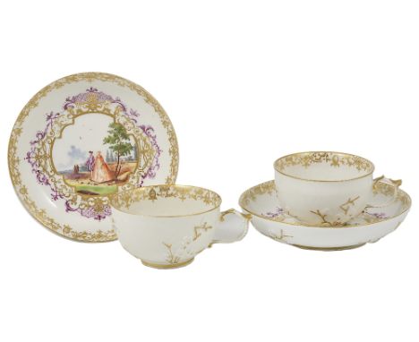 A PAIR OF MEISSEN TEACUPS AND SAUCERS, CIRCA 1730-35 with moulded flowers to the exterior, painted with quatrefoil panels of 