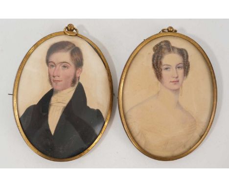 Mid 19th century English School, pair of portrait miniatures on paper, quarter length portrait of husband and wife, oval 10 x