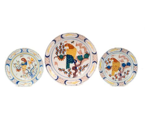 Trio of 18th century Dutch delftware plates, polychrome painted in the Chinese style with parrots, the smaller two measuring 