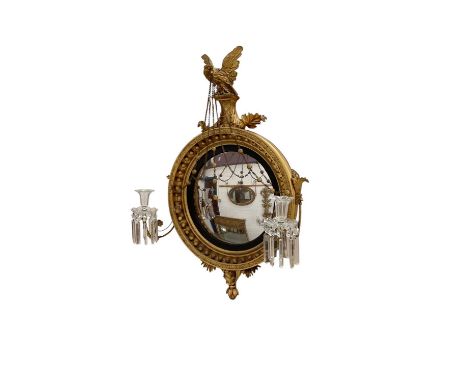Regency gilt convex girandole, with eagle surmount, the circular plate in ebonised slip and ball moulded concave frame with f