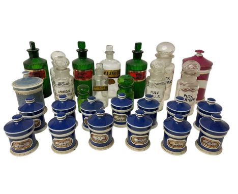 Collection of apothecary jars and bottles, including coloured glass, clear glass and ceramic, with various labels, many in La
