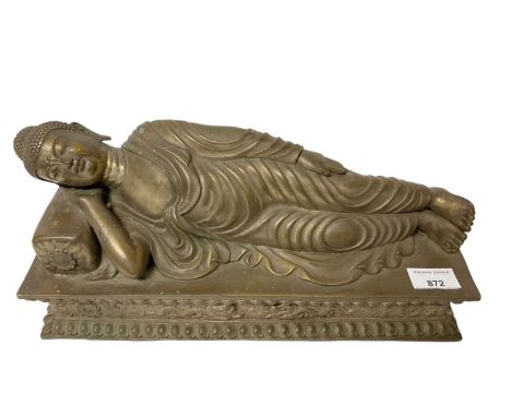Eastern bronze reclining buddha, on plinth base moulded with dragons, 37cm long