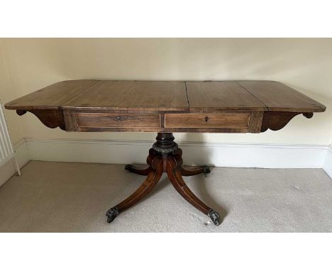 Regency rosewood sofa table, inlaid with stringing and brass circular medallions, the top with hinged sides, two frieze drawe