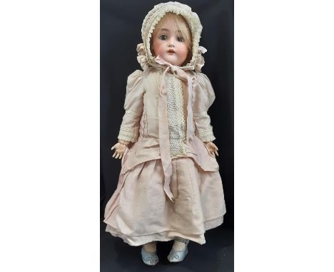 An early 20th Century bisque head doll by Kammer and Reinhardt, with jointed composition body, sleeping brown eyes, open mout