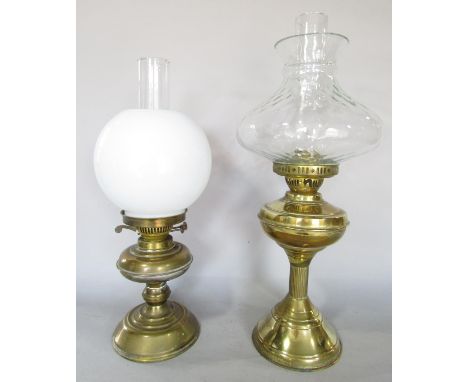 A brass oil lamp with a clear glass shade 53cm high and another brass oil lamp with a white opaque shade, 47cm high. 