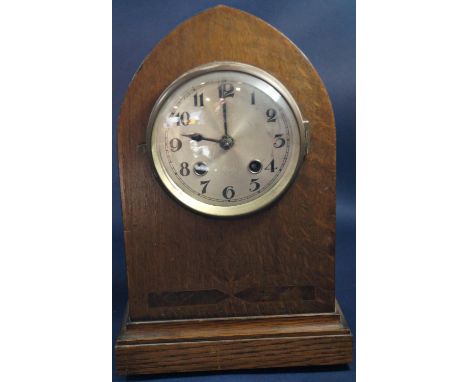 An Edwardian oak lancet shaped mantle clock with eight day striking movement 