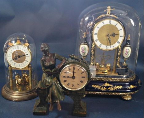 A contemporary mantle clock in ceramic and set beneath a glass dome with quartz movement, together with two further decorativ