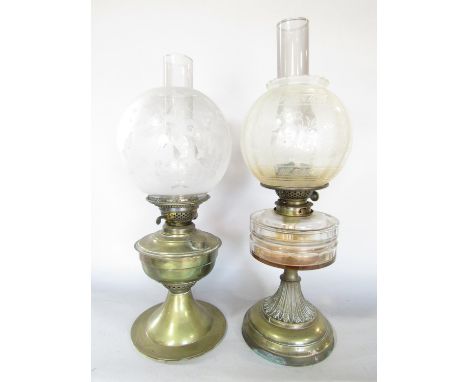A Victorian brass oil lamp with a floral etched glass shade 48cm high, and another brass oil lamp with a glass font and etche