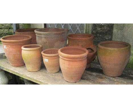 Seven weathered contemporary terracotta planters to include  a set of graduated size, together with a strawberry planter in t