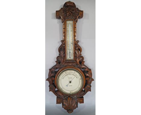 A Victorian aneroid barometer by Dolland London with carved walnut frame 
