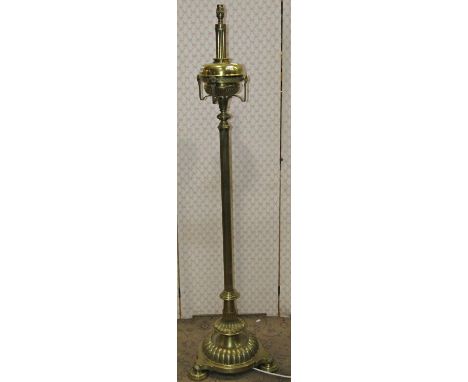 A Victorian brass oil lamp standard with reeded column, brass font and decorative finish, later adapted for electricity 