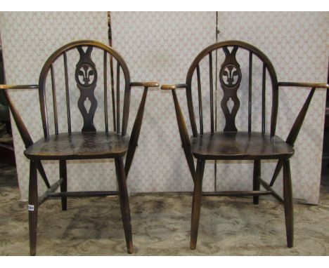 A pair of Ercol stained elm and beechwood low hoop and stick back open armchairs with pierced splats 