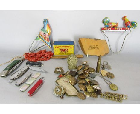 A miscellaneous collection of items including some army buttons, corporals stripes, two tin mechanical toys, a string of pink