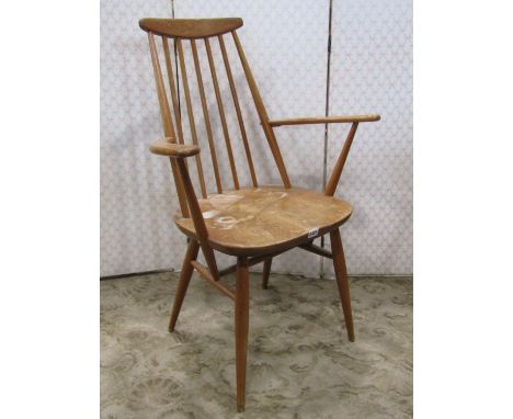 An Ercol stick back elbow chair on turned supports 