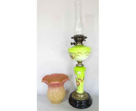 A Victorian Sunlight oil lamp with a green glass floral decorated body and font 71cm high, and an unrelated pink/yellow mottl