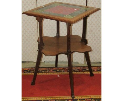 An Arts and Crafts oak two tier occasional table with inset ceramic tiled top, raised on square tapered and splayed supports 