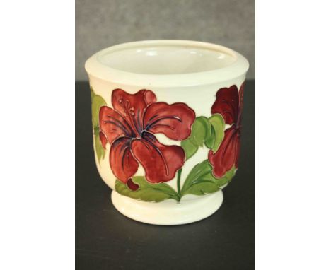 A Moorcroft pottery planter, red and yellow Hibiscus on cream ground. Signed to base. H.11 Dia.8cm. 